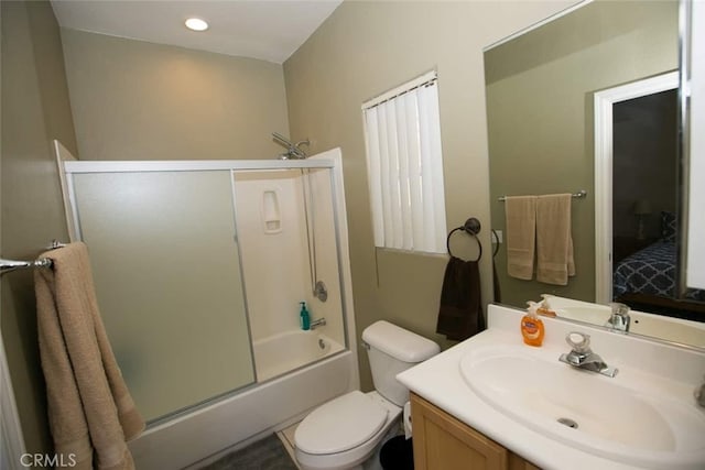 full bathroom featuring vanity, bath / shower combo with glass door, and toilet