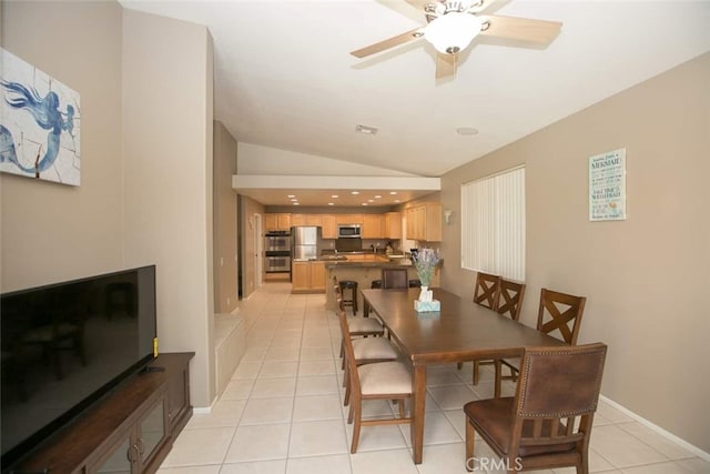 tiled dining space featuring ceiling fan and lofted ceiling