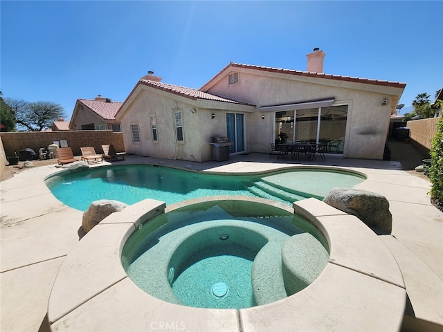 view of swimming pool with an in ground hot tub, area for grilling, and a patio area