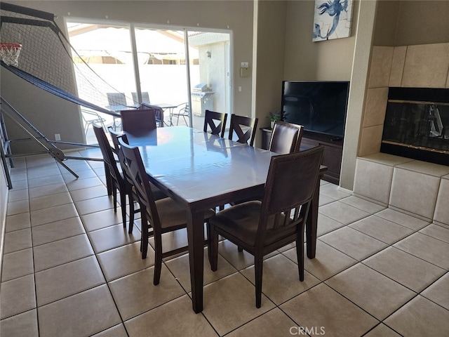 dining space featuring a tile fireplace and light tile patterned floors