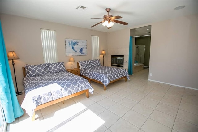 bedroom featuring a tile fireplace, light tile patterned floors, and ceiling fan