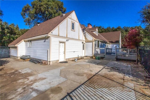 exterior space with a wooden deck and a patio