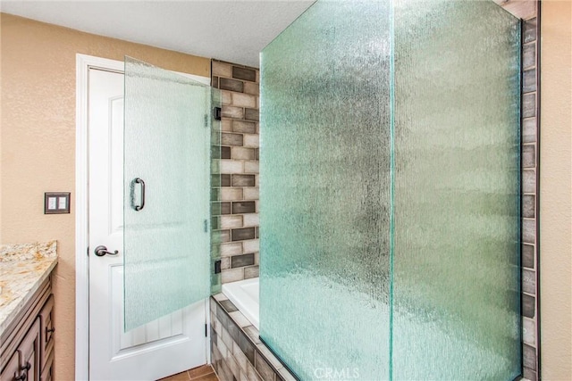 full bathroom featuring a relaxing tiled tub, a tile shower, and vanity