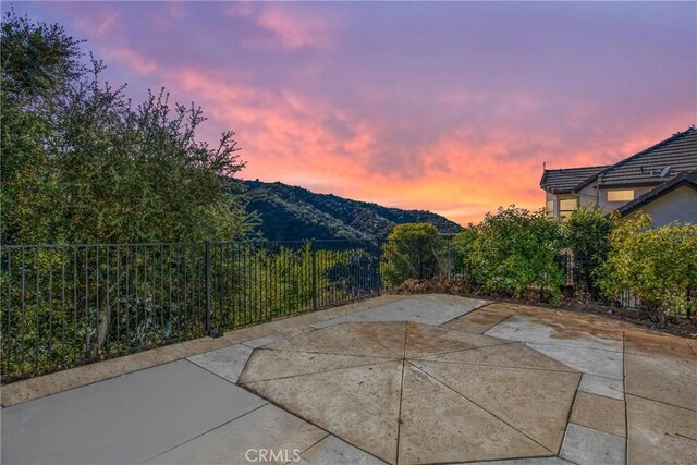 patio terrace at dusk featuring a mountain view