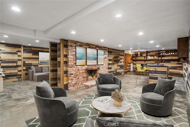 interior space featuring bar, recessed lighting, concrete floors, wood walls, and a brick fireplace