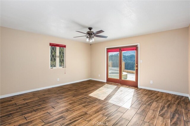 spare room featuring ceiling fan, plenty of natural light, and dark hardwood / wood-style flooring