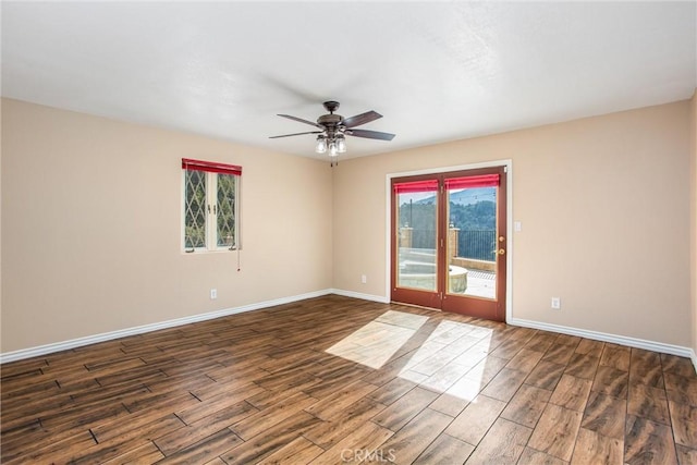 unfurnished room featuring a healthy amount of sunlight, dark wood finished floors, and baseboards