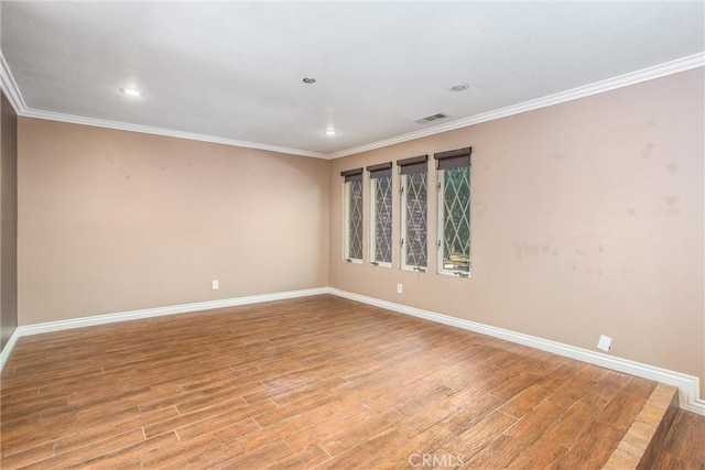 unfurnished room with hardwood / wood-style flooring and crown molding