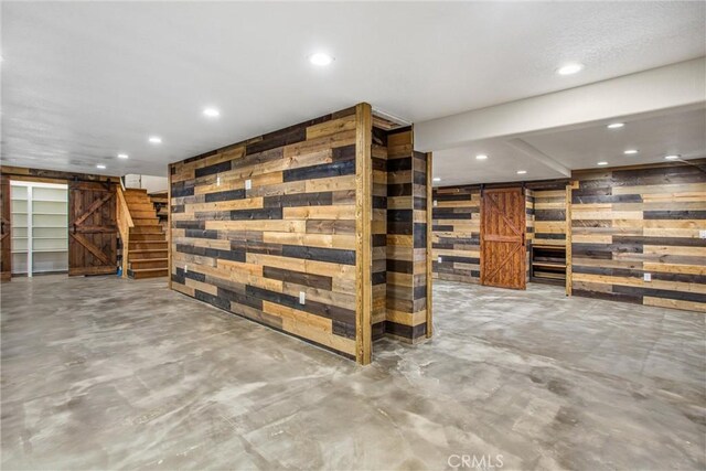 interior space featuring a barn door and wood walls