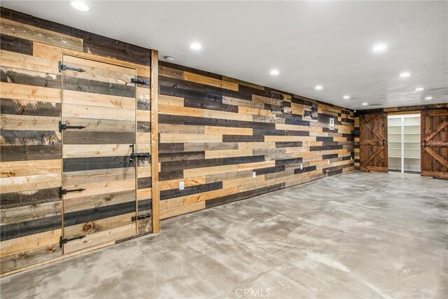 interior space with wooden walls and a barn door