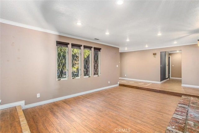 empty room with ornamental molding and light wood-type flooring