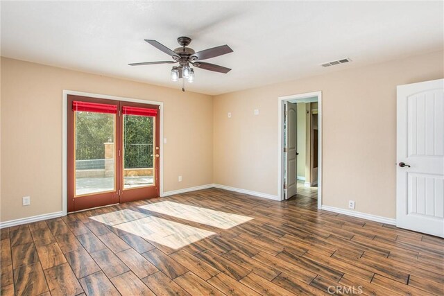 spare room featuring dark wood-type flooring and ceiling fan