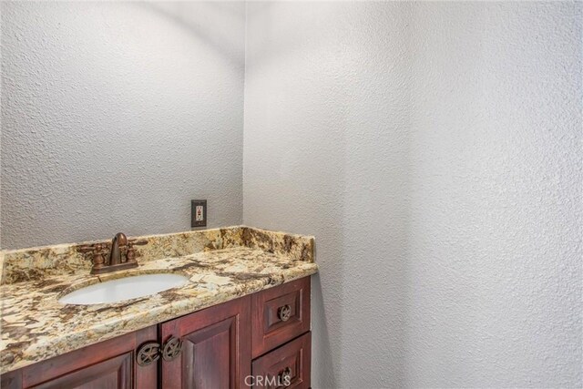 bathroom with a textured wall and a sink