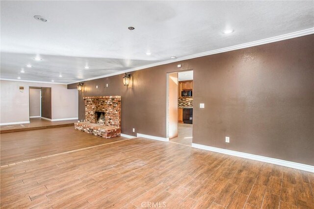 unfurnished living room with crown molding, hardwood / wood-style flooring, and a fireplace