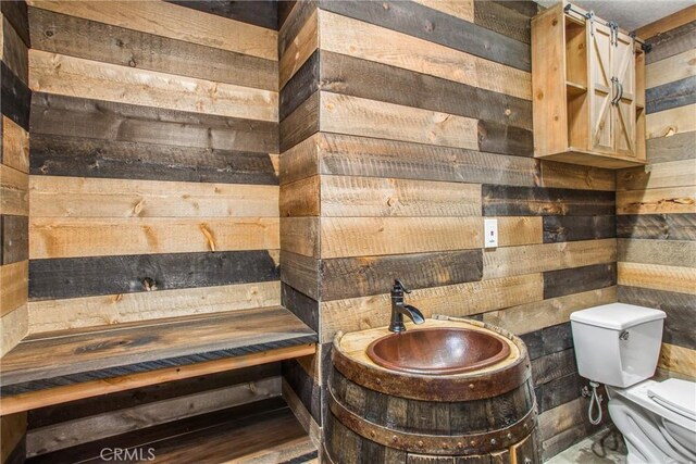 bathroom with wooden walls and toilet