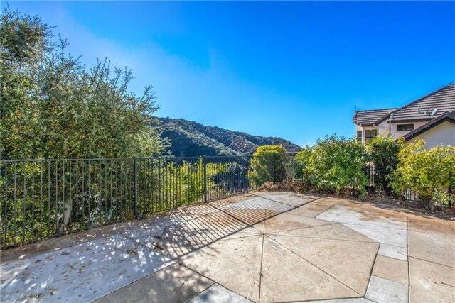 view of patio featuring fence and a mountain view