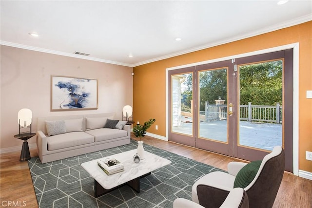 living room featuring baseboards, recessed lighting, wood finished floors, and crown molding