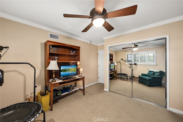 exercise area featuring ceiling fan, light colored carpet, and ornamental molding