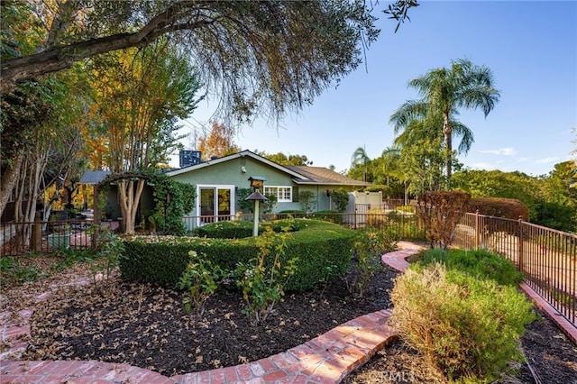 view of front of house featuring stucco siding and fence private yard