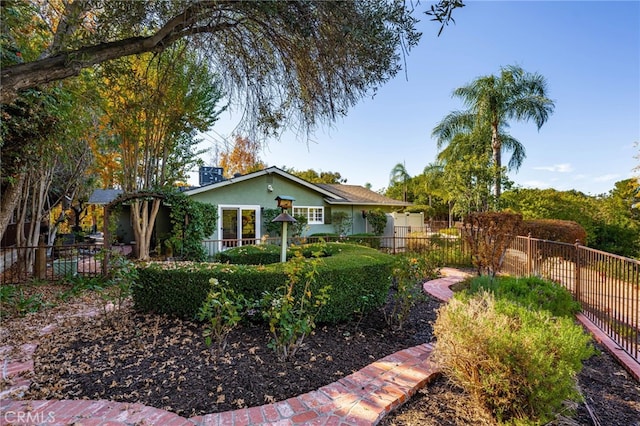 view of front facade featuring stucco siding and fence private yard
