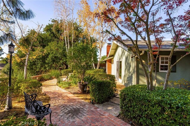 view of side of home with a patio area, a chimney, and stucco siding