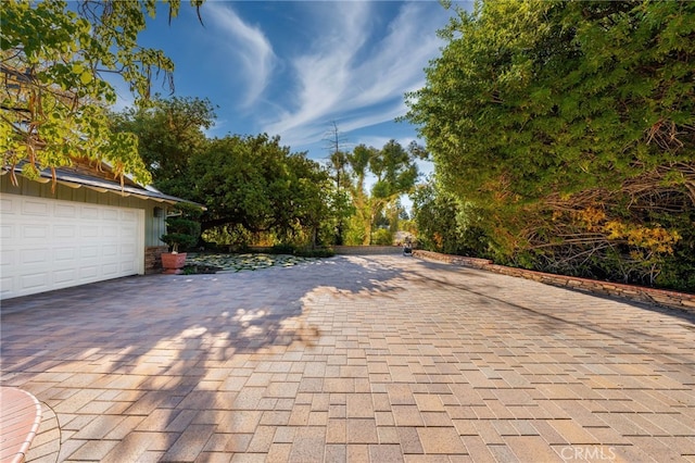 view of patio featuring a garage and decorative driveway
