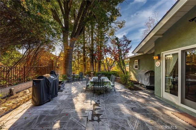 view of patio / terrace with area for grilling, outdoor dining area, and fence