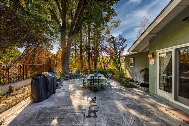 view of patio featuring area for grilling, a fenced backyard, and outdoor dining area