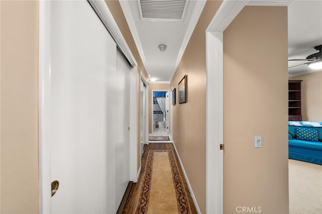 hall with wood-type flooring and ornamental molding