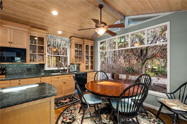 kitchen featuring light wood-type flooring, wood ceiling, black appliances, dark stone countertops, and vaulted ceiling with beams