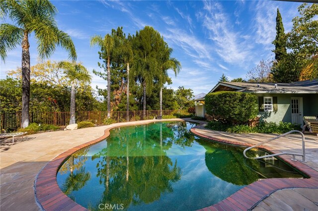 view of pool with a patio area, a fenced in pool, and fence