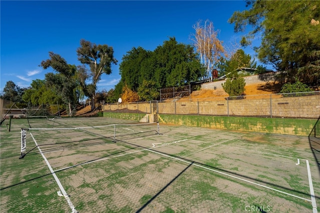 view of yard featuring a tennis court and fence