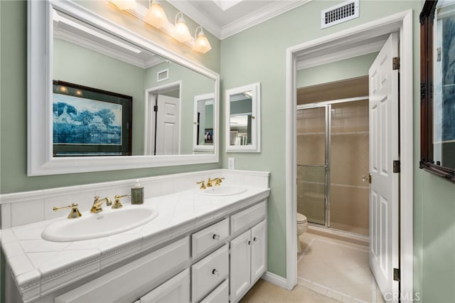 bathroom featuring vanity, tile patterned floors, crown molding, toilet, and a shower with shower door