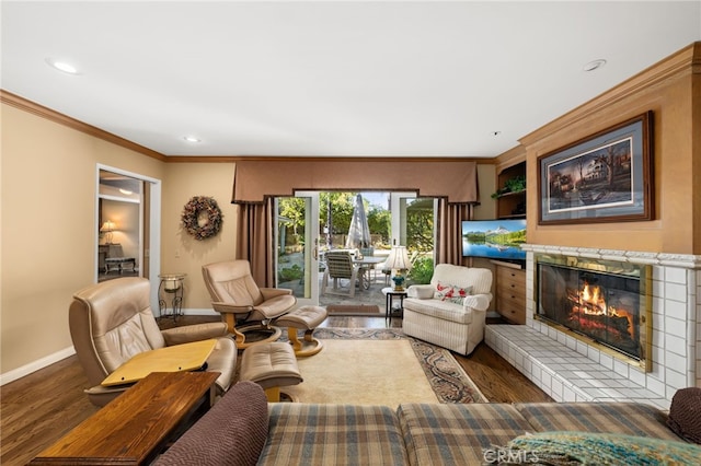 living room featuring a tile fireplace, ornamental molding, and hardwood / wood-style flooring