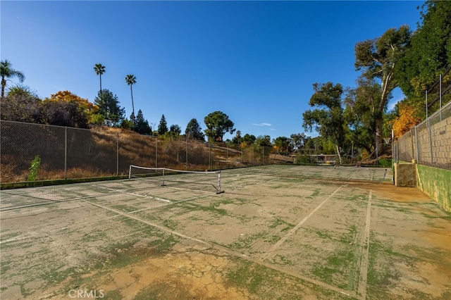 view of yard featuring fence and a tennis court
