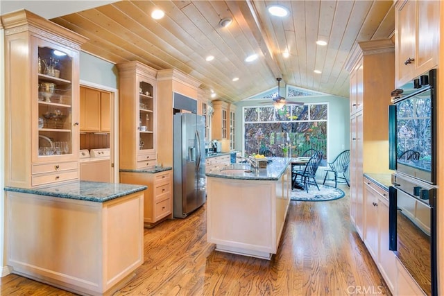 kitchen with vaulted ceiling, independent washer and dryer, a center island, wood ceiling, and stainless steel refrigerator with ice dispenser