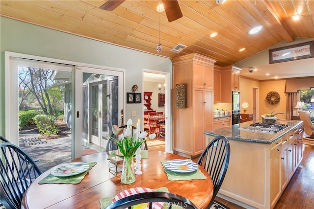 dining area with a wealth of natural light, visible vents, vaulted ceiling with beams, and wood ceiling