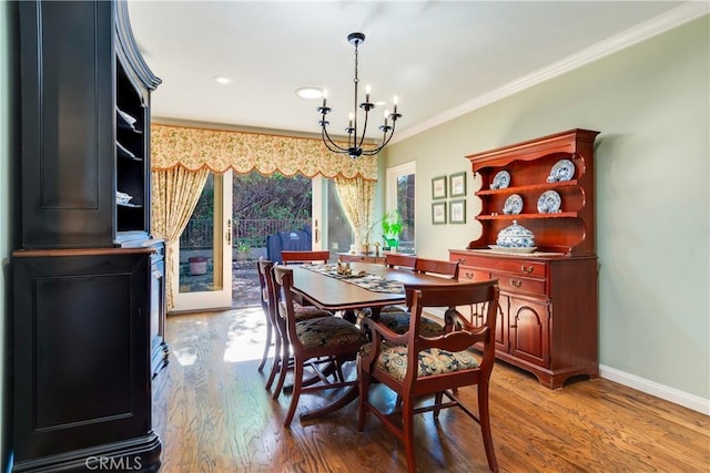 dining space featuring light wood-style flooring, baseboards, recessed lighting, a notable chandelier, and crown molding