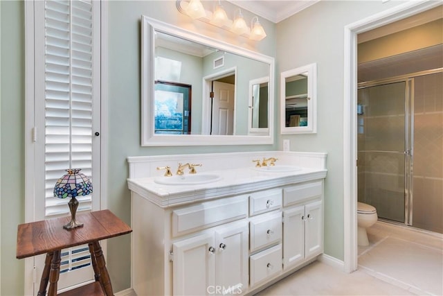 bathroom featuring a shower stall, toilet, ornamental molding, and a sink