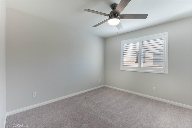 carpeted spare room featuring ceiling fan