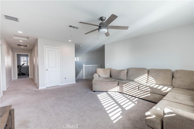 carpeted living room with ceiling fan