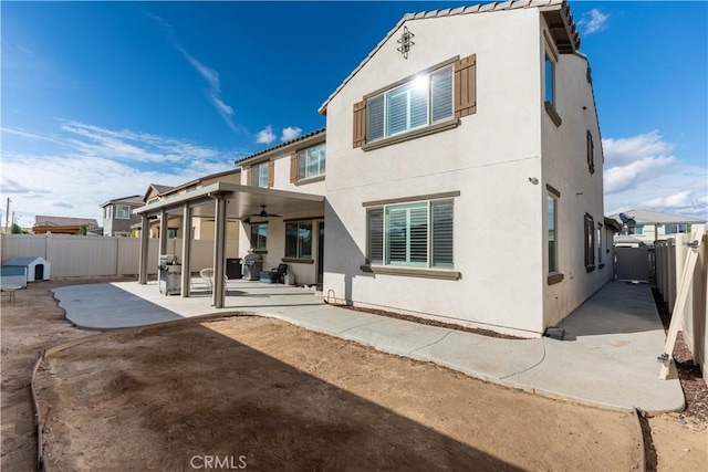 rear view of property with ceiling fan and a patio