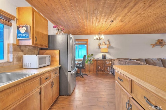 kitchen with a notable chandelier, a healthy amount of sunlight, wooden ceiling, and decorative light fixtures