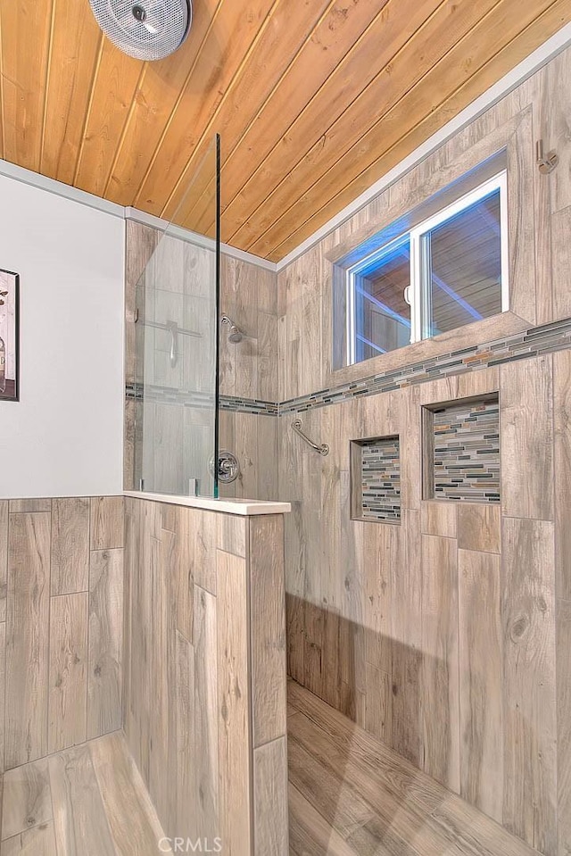 bathroom featuring a tile shower and wooden ceiling