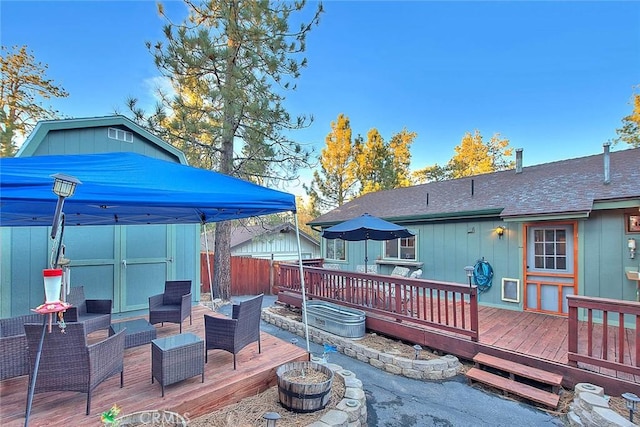 wooden terrace with a storage unit and an outdoor hangout area