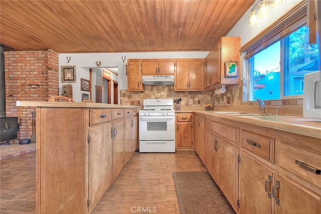 kitchen with a wood stove, sink, decorative backsplash, light hardwood / wood-style floors, and white gas range oven