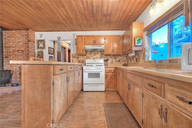 kitchen featuring under cabinet range hood, light countertops, wooden ceiling, white gas stove, and a peninsula