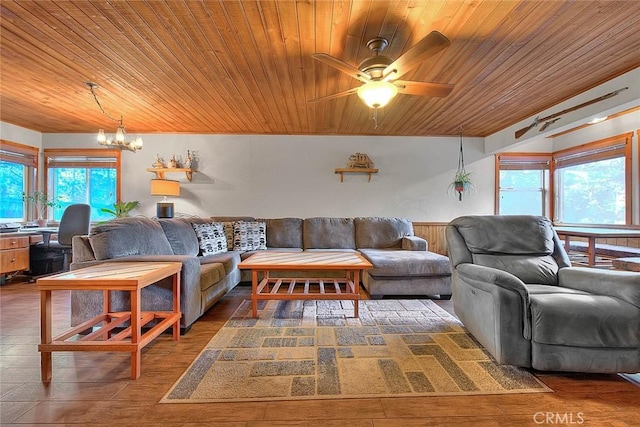 living room with wood ceiling, a wealth of natural light, and ceiling fan with notable chandelier