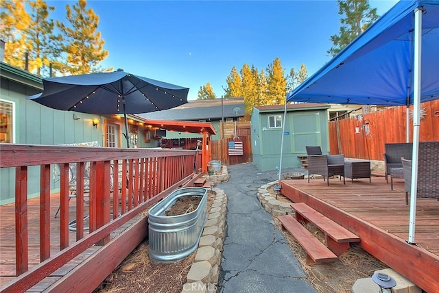 exterior space featuring a storage shed, a fenced backyard, and an outdoor structure