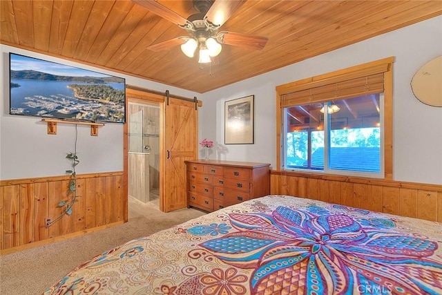 carpeted bedroom featuring wood ceiling, wainscoting, wood walls, and a barn door